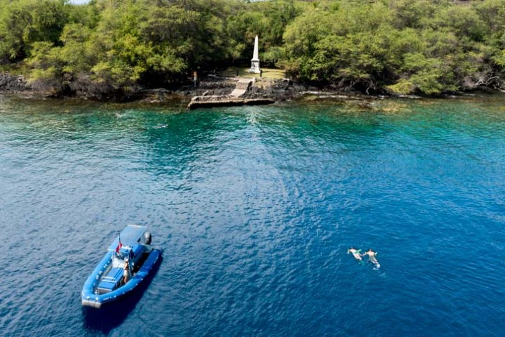 aerial view of a boat sitting in the ocean near the captain cook monument