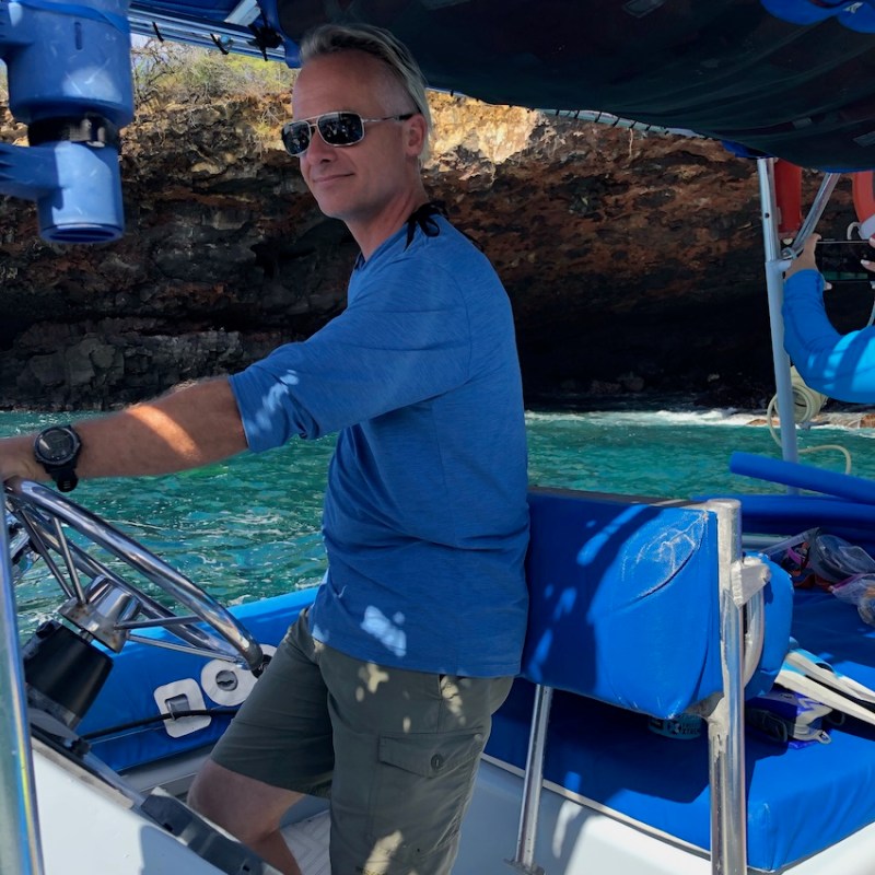 a person in a blue shirt standing in front of a boat
