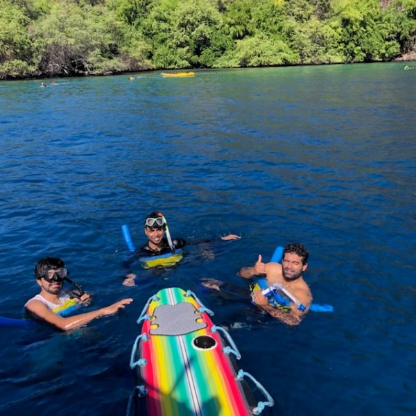 a group of people standing next to a body of water