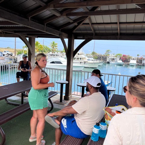 a group of people sitting at a dock