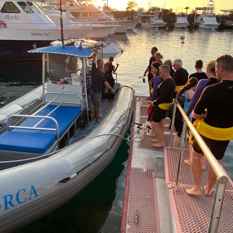 a group of people in a boat docked next to a body of water