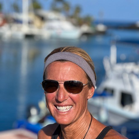 a man wearing sunglasses in front of a body of water