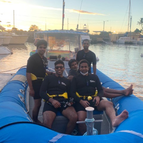 a group of people sitting in a boat on a body of water