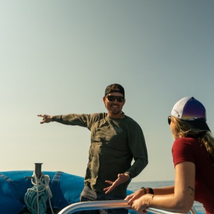 a man and a woman riding on the back of a boat
