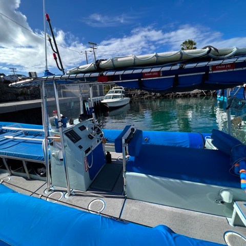 a blue and white boat sitting next to a body of water