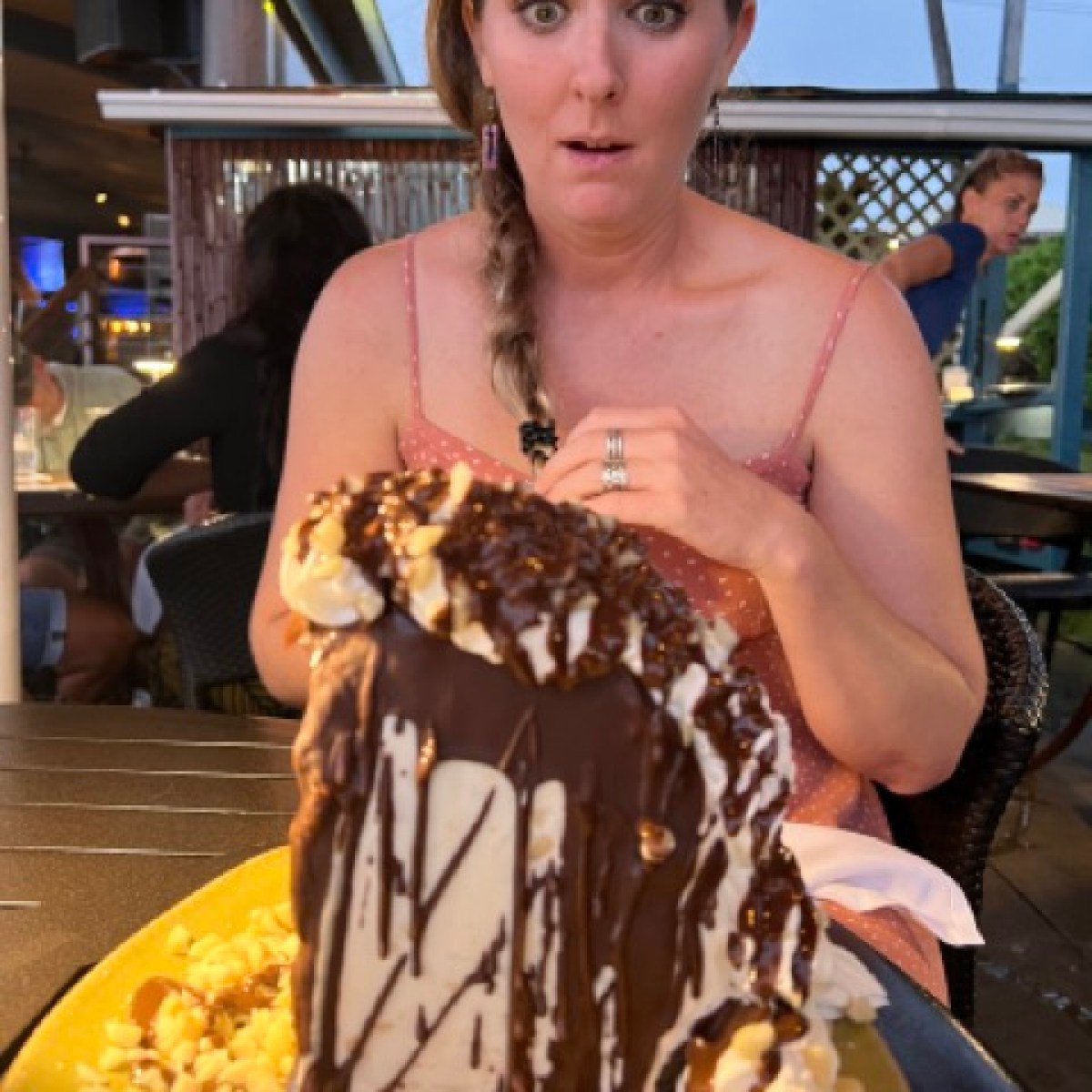 a person sitting at a table with a cake on a plate