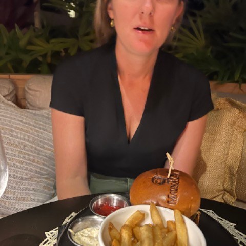 a woman sitting at a table with a plate of food