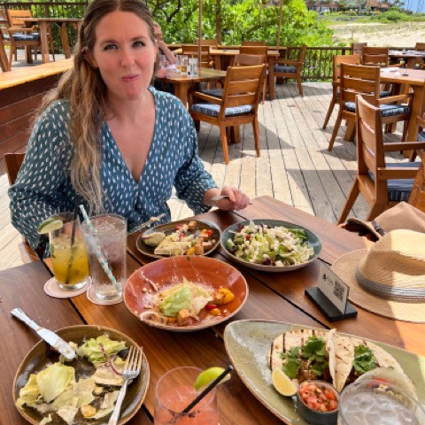 a woman sitting at a table with a plate of food