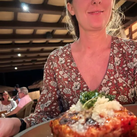 a woman sitting at a table with a plate of food
