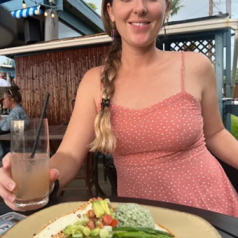 a woman sitting at a table with a plate of food