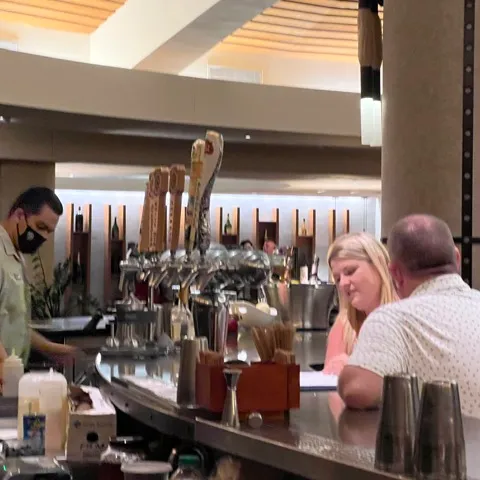 a group of people standing in a kitchen preparing food