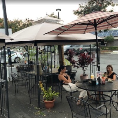a group of people sitting at a table in front of a building