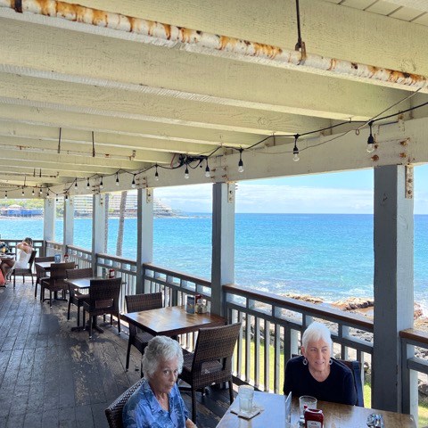 a group of people sitting on a bench overlooking a body of water