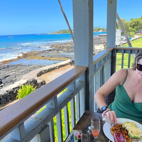 a woman sitting at a table with food and water