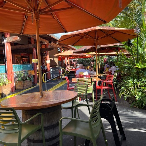 a group of people sitting at a table with an umbrella