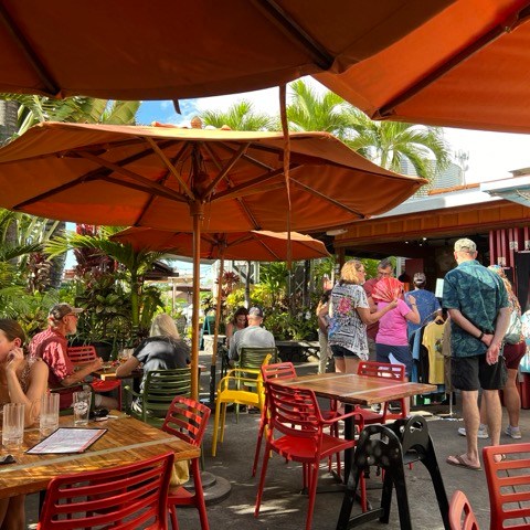 a group of people sitting at a table with an umbrella