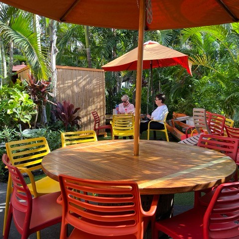 a group of people sitting at a table with an umbrella