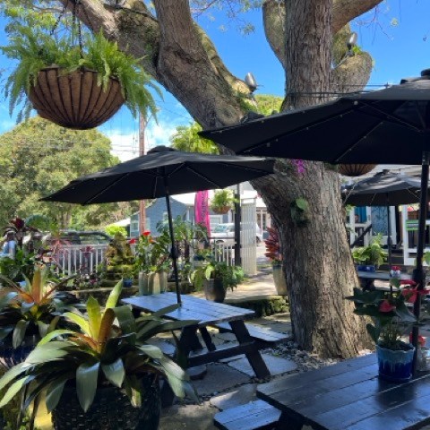 a group of people sitting at a table with an umbrella