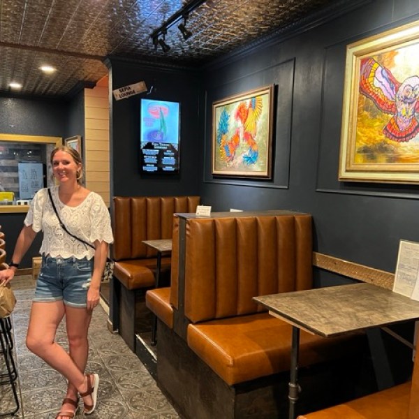 a person standing against a bar with seating nearby