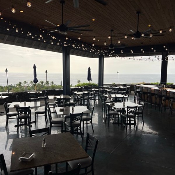 inside an open restaurant with bright dangly lights and open walls to the exterior