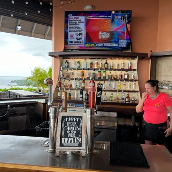 a bar with a bartender and a sign saying 