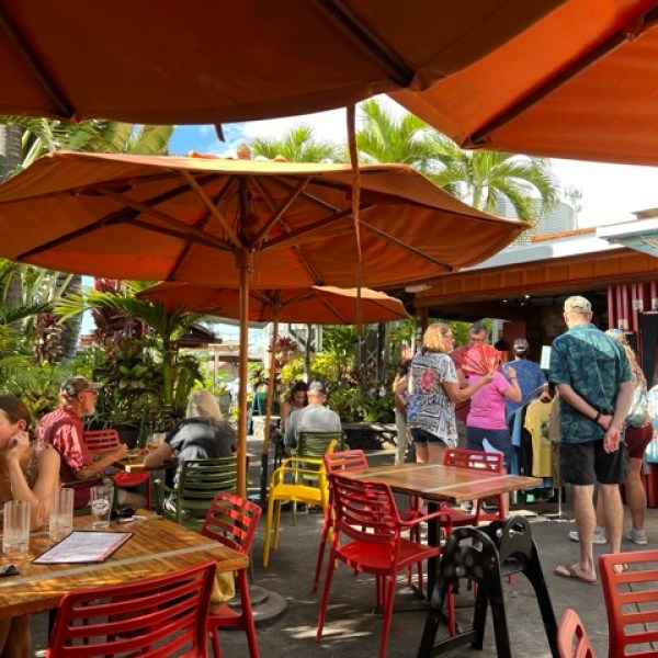 a group of people sitting at a table with an umbrella