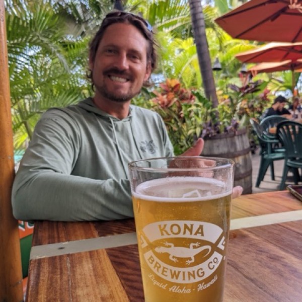 Byron Kay sitting at a table with a cup of beer