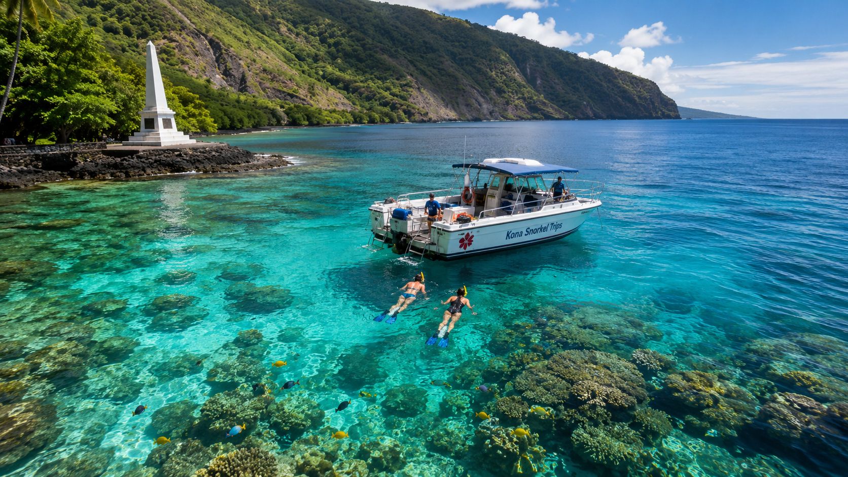 Two people snorkeling near a boat over a coral reef by a lush, mountainous coastline.